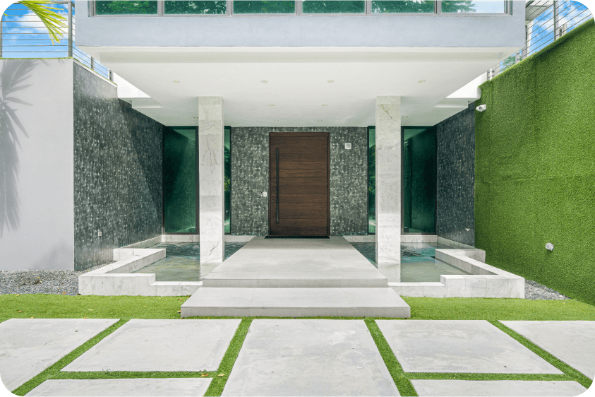 Elegant front entrance with wooden double doors, marble columns, and reflecting pools in luxury Pinecrest home