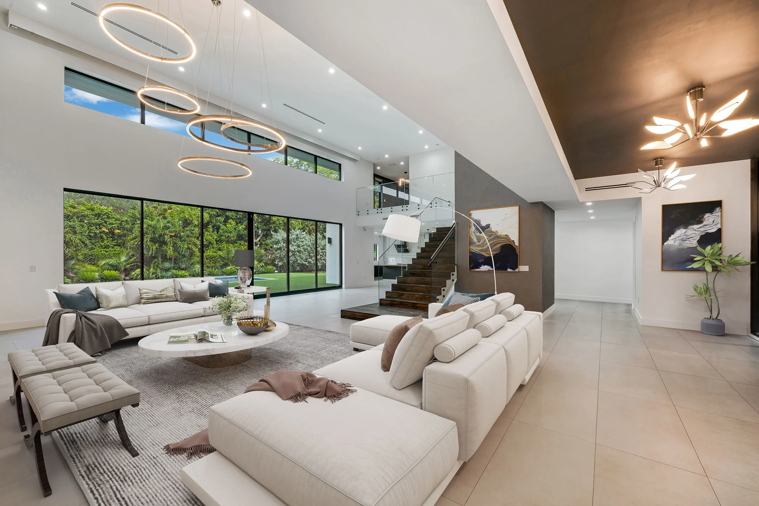 Side view of the main lounge with bright furniture, large windows, and garden access in luxury Pinecrest house