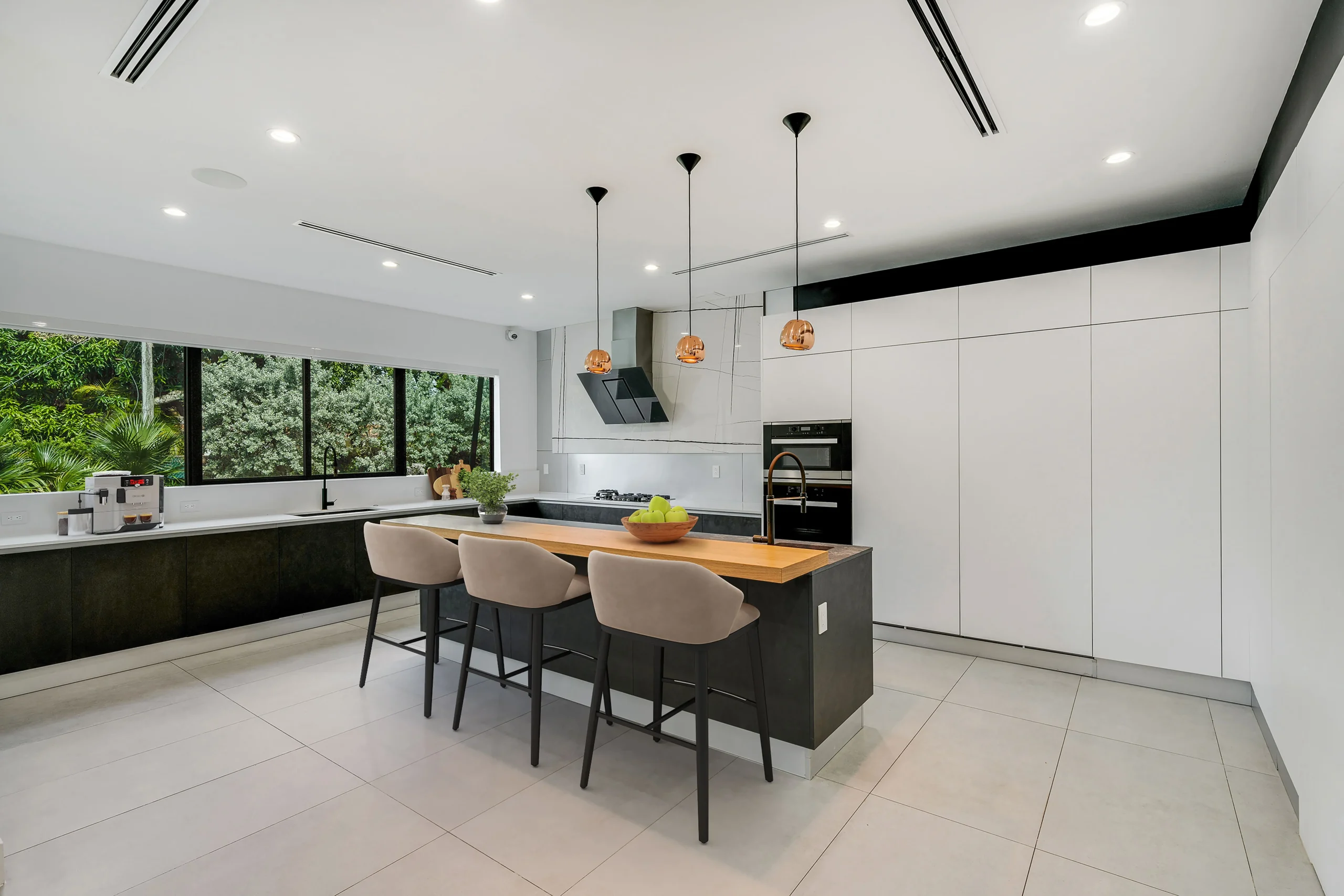 Contemporary kitchen with central island, built-in appliances, and garden view in Pinecrest