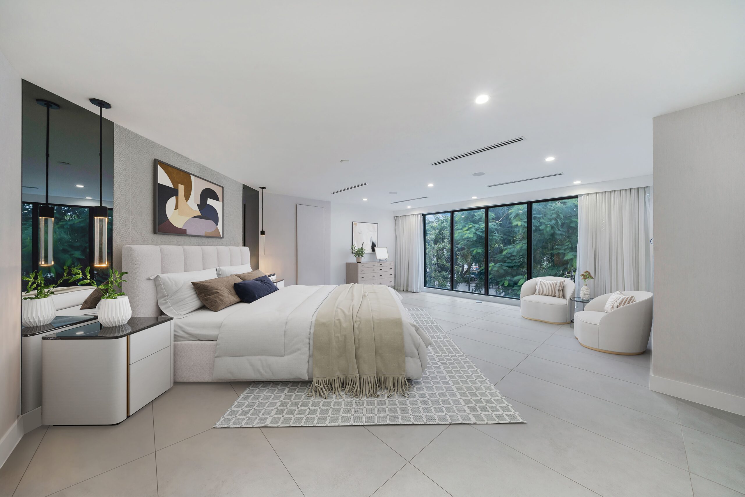 Large primary bedroom with panoramic windows, elegant design, and sitting areas in exclusive Pinecrest property