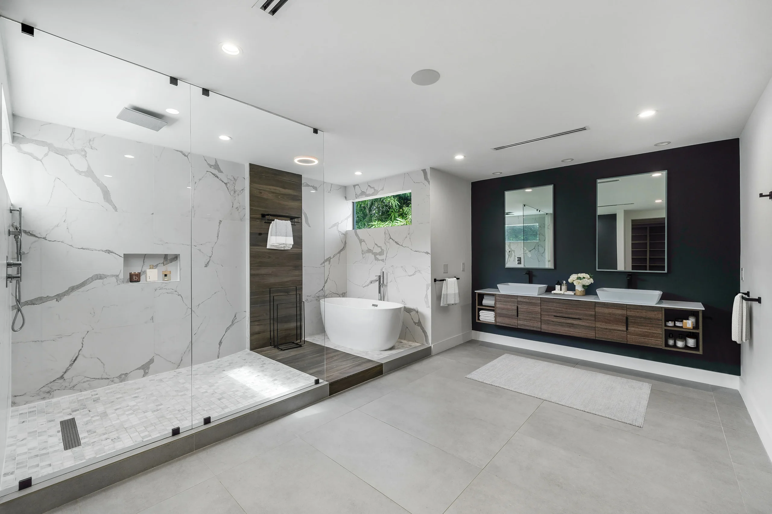 Main bathroom with spa-style shower, standalone tub, and marble finishes in Pinecrest luxury home